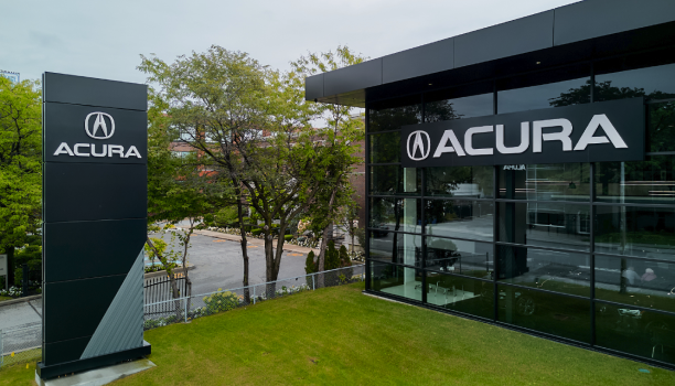 The exterior of an Acura dealership is shown.